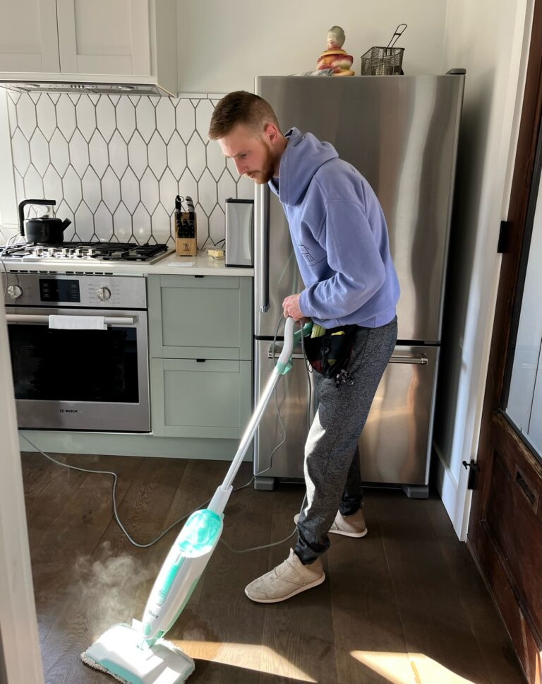 A&H Natural Cleaning employee steam mopping the floor