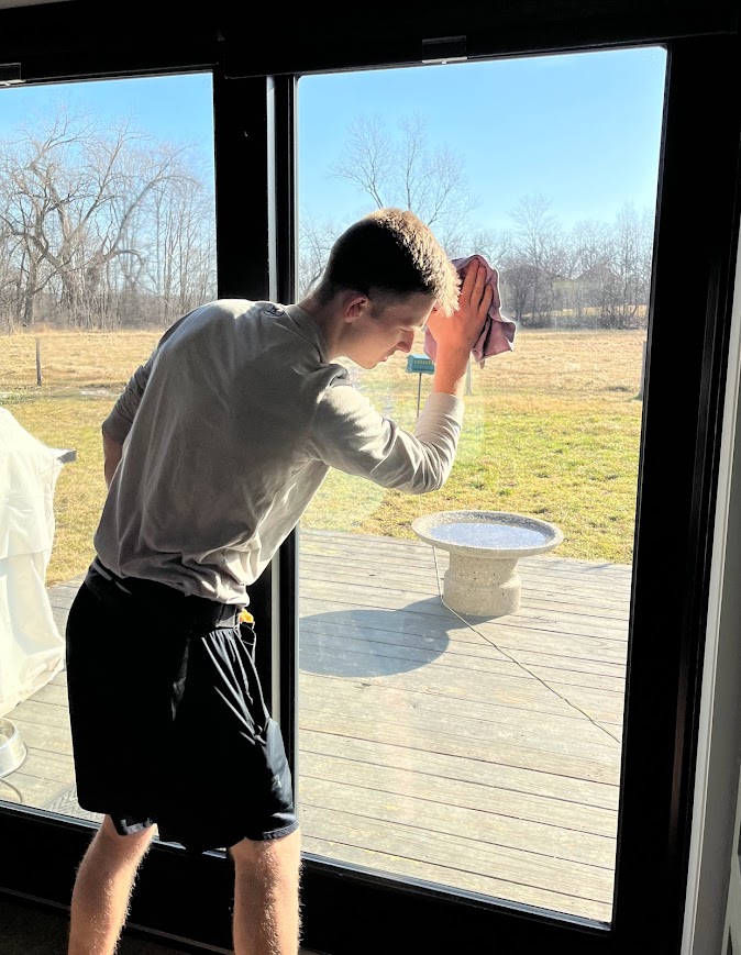 A&H Natural Cleaning employee cleaning a window