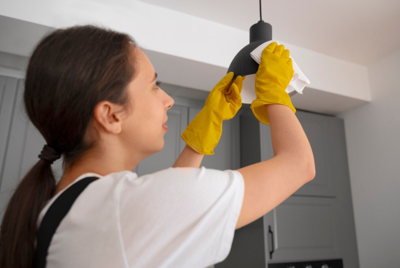 a woman cleaning a light fixture